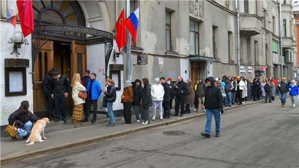 Russlands Wahlkommission spricht Putin Rekordergebnis zu Wählerinnen und Wähler stehen um 12 Uhr mittags Ortszeit vor einem Wahllokal in Moskau an. Kremlgegner hatten zuvor zu der Aktion „Mittag gegen Putin“ aufgerufen.
