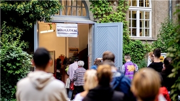 Wählerinnen und Wähler warten im Stadtteil Prenzlauer Berg in einer langen Schlange vor einem Wahllokal.