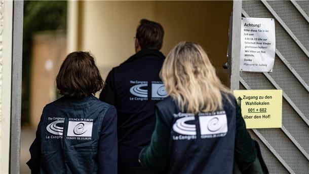 Wahlbeobachter des Europäischen Rates betreten ein Berliner Wahllokal.