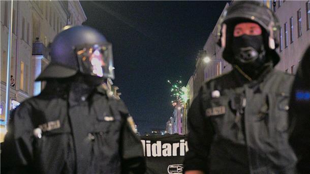 Walpurgisnacht in Berlin war eher ruhig, obwohl hinter der Demonstration ein Feuerwerk gezündet wird.