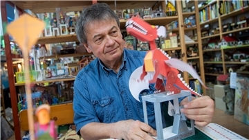 Walter Ruffler zeigt eine seiner Papierskulpturen, die als Ausschneide- und Bastelbögen in die ganze Welt verkauft werden.
