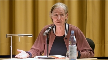 Eine Frau sitzt am Tisch, auf dem ein Mikrofon steht: die Autorin Judith Kuckart bei den Literarischen Wochen.