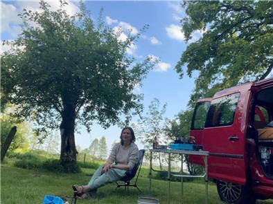 Frau auf Campingstuhl im Grünen