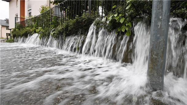 Wasser strömt auf eine Straße in Viktring bei Klagenfurt in Kärnten.