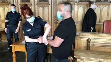 Polizistin legt einem verdächtigen Mann Handschellen an.