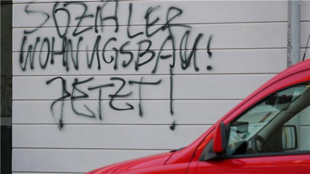 Ein Graffiti «Sozialer Wohnungsbau! Jetzt!» steht an einem neuen Mietshaus einer Wohnungsbaugenossenschaft.