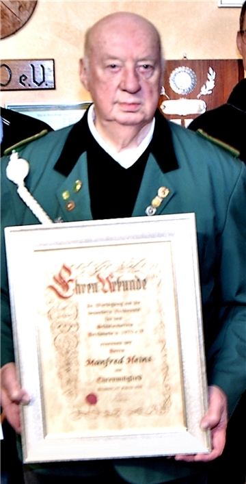 Manfred Heins hält die Urkunde für seine Ernennung zum Ehrenmitglied des Schützenvereins Bexhövede