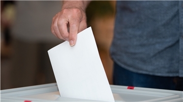 Ein Wähler wirft in einem Wahllokal seinen Stimmzettel in die Wahlurne: 
