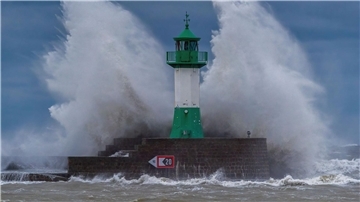 Wellen der Ostsee peitschen bei einem schweren Sturmtief an den Leuchtturm auf der Ostmole. Wegen des Sturmtiefs sind an der Ostseeküste Straßen und Uferbereiche vom Hochwasser überschwemmt worden.