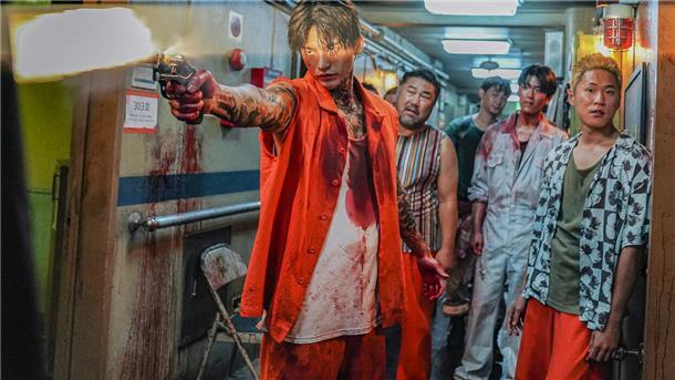 Katz-und-Maus-Spiele mit Romantik und Kunstblut Eine Gruppe südkoreanischer Krimineller stehen in einem blutverschmierten Gang eines Schiffes. Ein Mann zielt mit einer Waffe.