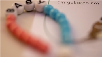 Ein neues Kettchen liegt für ein Baby bereit.