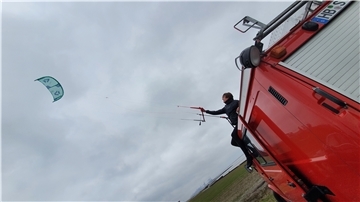 Wenn das Hochwasser am Wremer Strand mal auf sich warten lässt, klettert Ansgar Pahl für eine Trockenübung auch mal auf sein ausgedientes Feuerwehrfahrzeug, von dem aus er die Kiteschule in diesem Jahr betreibt.