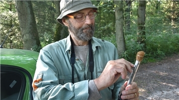 Das Bild zeigt Werner Burkart, wie er seinen Angelstab präsentiert.  