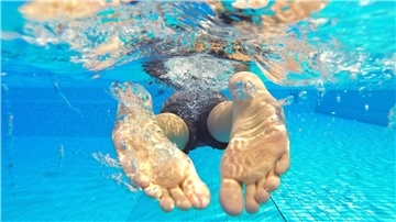 Füße eines Schwimmers im Wasser