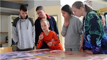 Kinder und Erwachsene spielen Memory