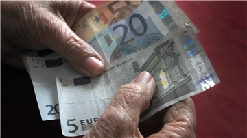Eine Person hält Geldscheine in der Hand