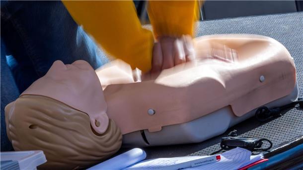 ein Mann übt an einer Puppe die Herz-Massage