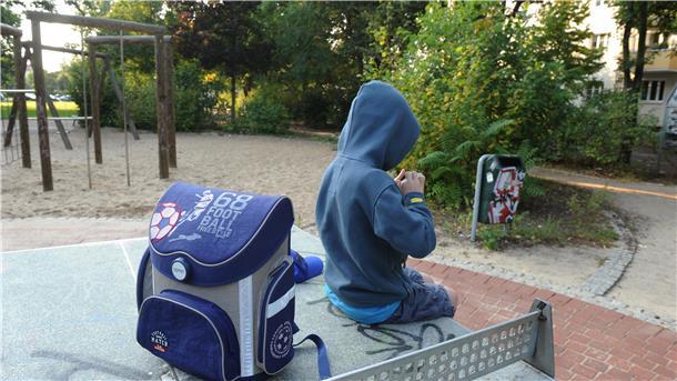  Ein Junge sitzt am 22.08.2012 mit seinem Schulranzen auf einer Tischtennisplatte auf einem Spielplatz in Berlin. 
