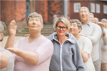 Frau zwischen lauter Beton-Figuren
