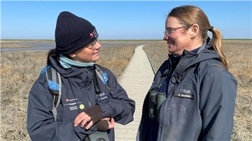 Zwei Frauen in blauen Jacken und mit Ferngläsern. Wer mit den beiden Nationalpark-Rangerinnen Susanne Koschel und Annelie Hedden über den Langwarder Groden streift, entdeckt Wundersames.
