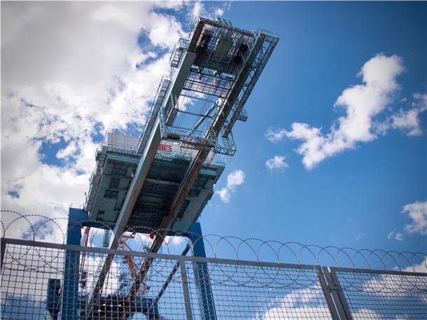 Kennen Sie diese traumhaften Fotospots in Bremerhaven? Wer nach links blickt, entdeckt hinter einem Zaun große Kräne, Container und riesige Autolandschaften.