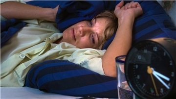 Eine Frau liegt im Bett.