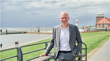 Mann steht auf dem Weserdeich