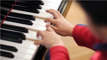 Bild von Kinderhänden, die Klavier spielen