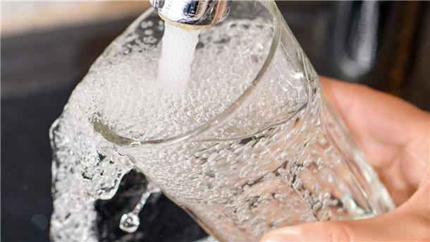 Aus dem Wasserhahn wird ein Glas befüllt. 