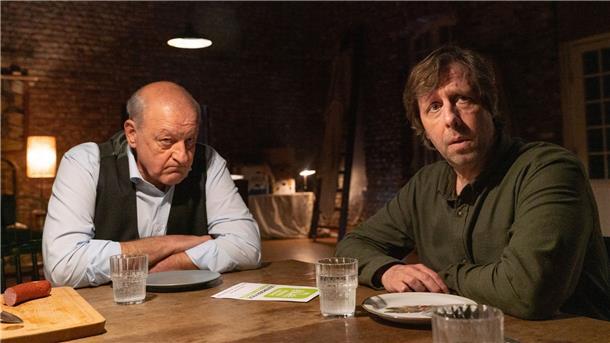 Wilsberg schnüffelt in der Fleischbranche Wilsberg (Leonard Lansink, l) ist sich nicht sicher, ob er den Auftrag über Ermittlungen im Veterinäramt annehmen soll, Ekki (Oliver Korittke, r) hat weniger Bedenken. in einer Szene aus „Wilsberg - Schmeckt nach Mord“ (undatiert). Der Krimi wird am 01.10.2022 im ZDF ausgestrahlt.