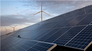 Windkraftanlagen stehen hinter Photovoltaikanlagen auf der Blocklanddeponie.