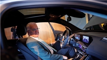 Winfried Kretschmann sitzt in einem Mercedes EQC.