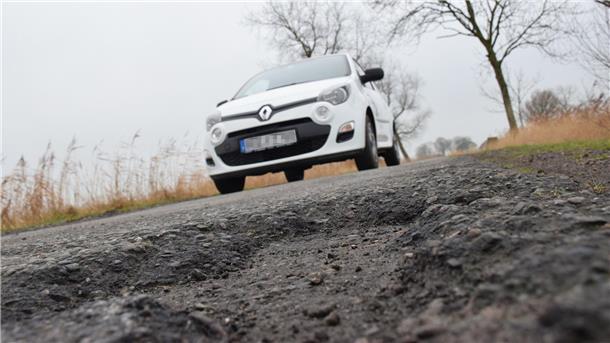 Auto auf kaputter Straße