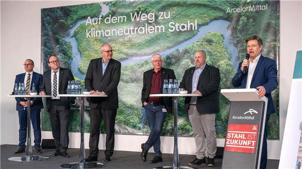 Wirtschaftsminister Robert Habeck (r) verkündet bei einer Betriebsversammlung die Förderzusage für den Umbau des Bremer Stahlwerks.