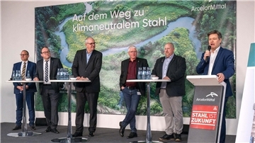 Wirtschaftsminister Robert Habeck (r) verkündet bei einer Betriebsversammlung die Förderzusage für den Umbau des Bremer Stahlwerks.