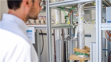 Wissenschaftler Fabian Klein vor dem Reaktor, mit dem synthetisches Gas gewonnen wird. Im nächsten Schritt soll die Produktionsanlage größer werden.