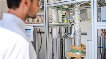 Wissenschaftler Fabian Klein vor dem Reaktor, mit dem synthetisches Gas gewonnen wird. Im nächsten Schritt soll die Produktionsanlage größer werden.