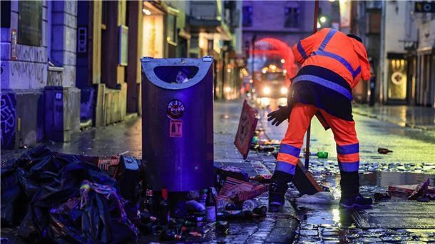 „Make Alaaf not war“: Karneval wieder ohne Corona-Regeln Wo gefeiert wird, fällt Müll an: Mitarbeiter der Straßenreinigung fegen in der Nacht in Köln den Abfall zusammen.