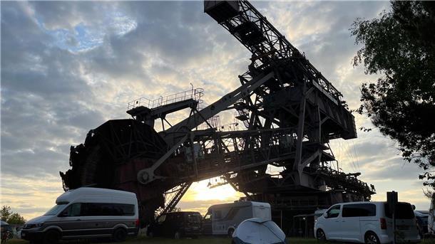 Nach Festival: Leiche auf Campingplatz gefunden Wohnwagen und Wohnmobile vor einem Schaufelradbagger in Ferropolis in Sachsen-Anhalt (Archivbild von 2023).