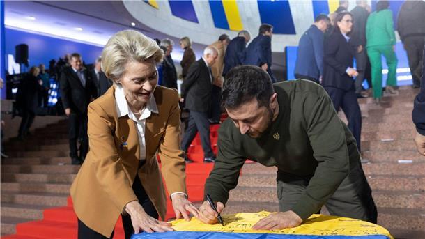 Von der Leyen mit EU-Kommission zu Gesprächen in Kiew Wolodymyr Selenskyj und Ursula von der Leyen schreiben ihre Wünsche auf eine ukrainische Flagge.
