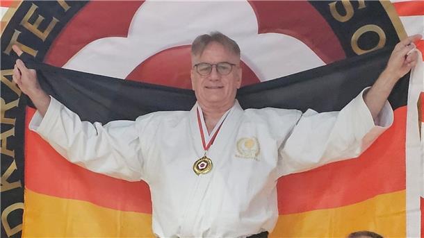 Karateka Holger Horn gewinnt Gold beim World Cup World Cup Sieger Holger Horn mit Fahne.