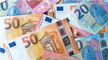 Zahlreiche Banknoten von 10, 20 und 50 Euro liegen auf einem Tisch.