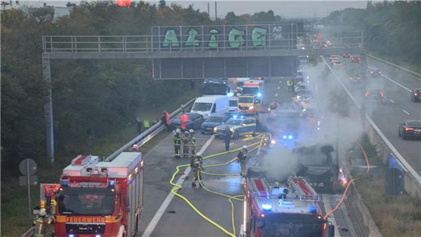 Zahlreiche Einsatzkräfte der Feuerwehr bei Löscharbeiten an einem brennenden Fahrzeug auf der A5.