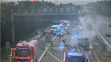 Zahlreiche Einsatzkräfte der Feuerwehr bei Löscharbeiten an einem brennenden Fahrzeug auf der A5.