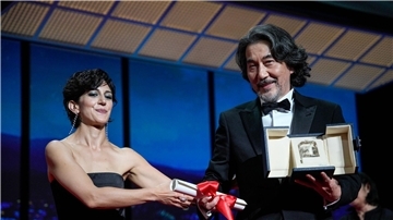Zahra Amir Ebrahimi (l) überreicht Koji Yakusho den Preis als bester Schauspieler für seine Rolle im Film „Perfect Days“ von Regisseur Wenders.