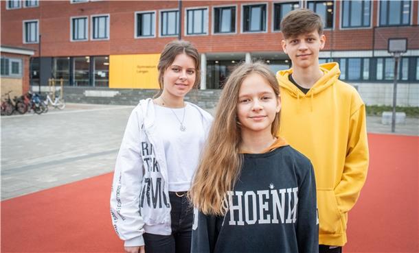 Die drei Jugendlichen stehen vor dem Gymnasium Langen