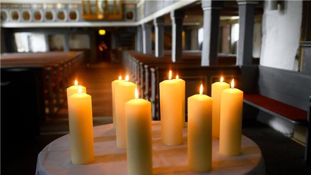 Zehn Kerzen für Beteiligte und Opfer stehen auf einem Tisch vor dem Altar in der St. Johannis Kirche.