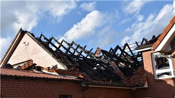Auf dem Foto ist das von dem Feuer betroffene Gebäude. Der Dachstuhl ist verkohlt, ein Fenster zerborsten. 