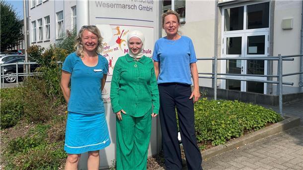 Drei Frauen vor einem Schild