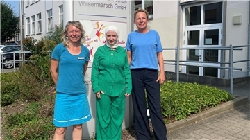 Drei Frauen vor einem Schild